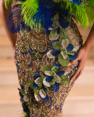 Close-up of intricate stone and feather details on blue and green dress