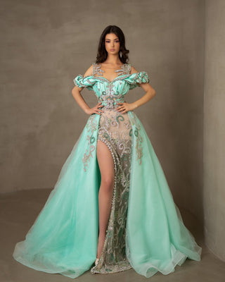Mint lace dress with a deep slit and detachable overskirt.