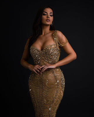 A glamorous gold dress adorned with shimmering crystals and intricate detailing.