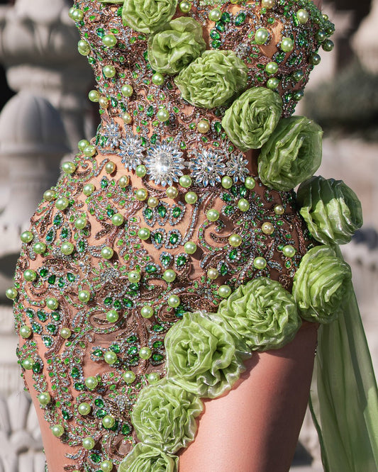 Stylish green gown with a dramatic slit and intricate floral design.