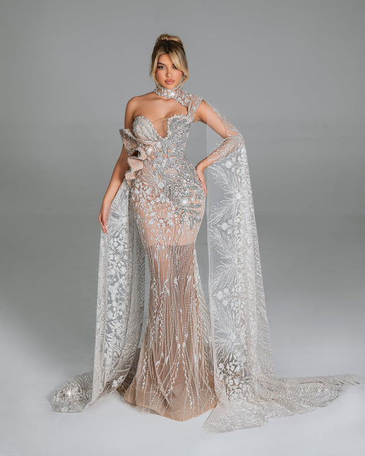 Crystal-embellished one-shoulder gown with flowing lace panels.