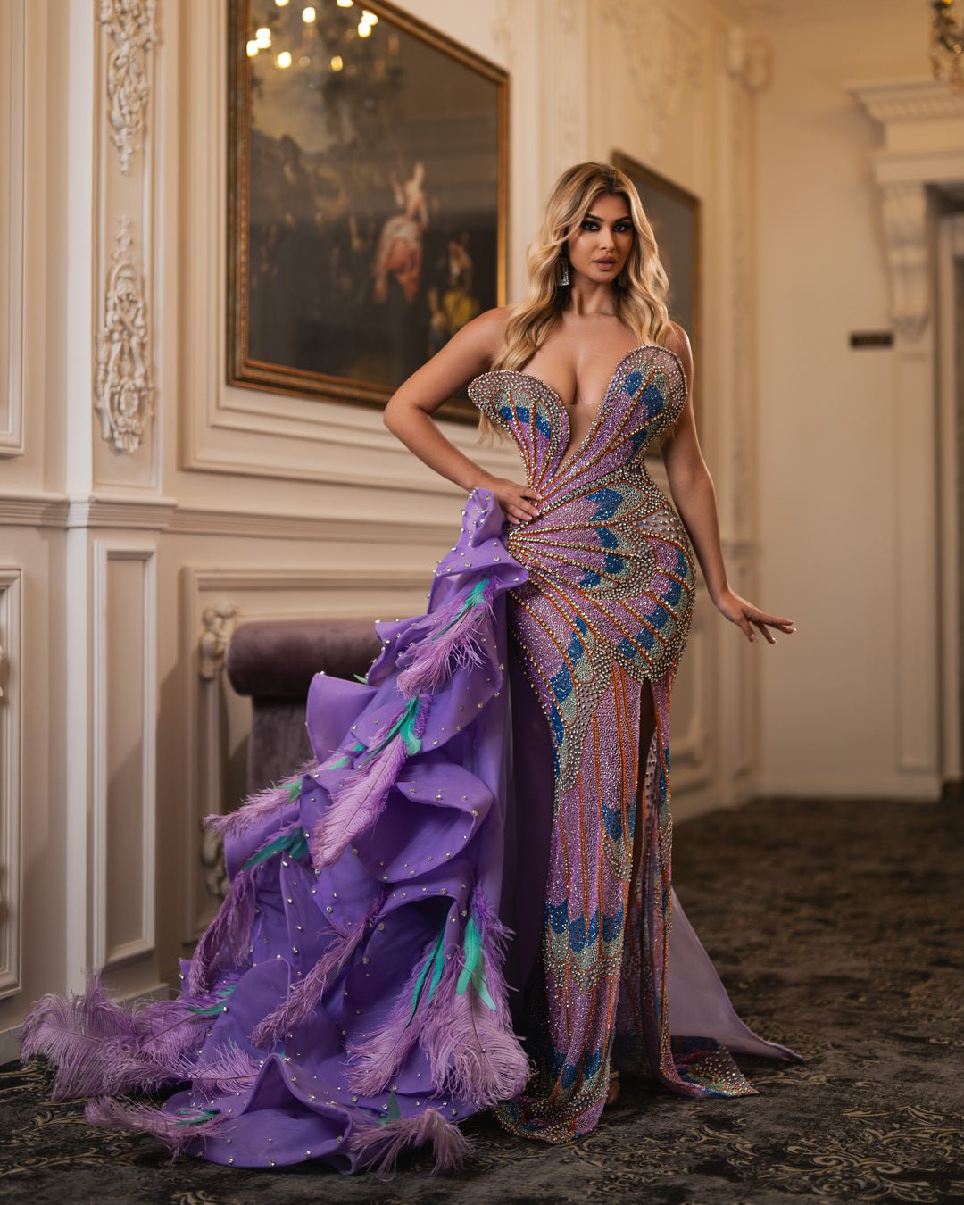 Dramatic sweetheart neckline and flowing train with vibrant purple fabric and feathers.