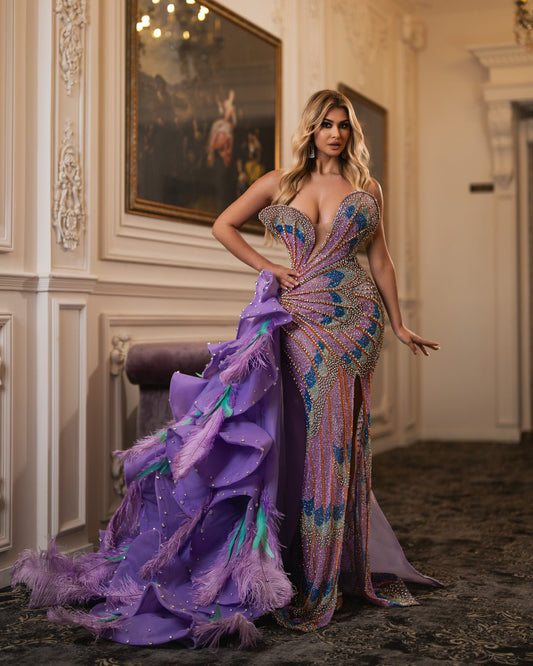 Dramatic sweetheart neckline and flowing train with vibrant purple fabric and feathers.