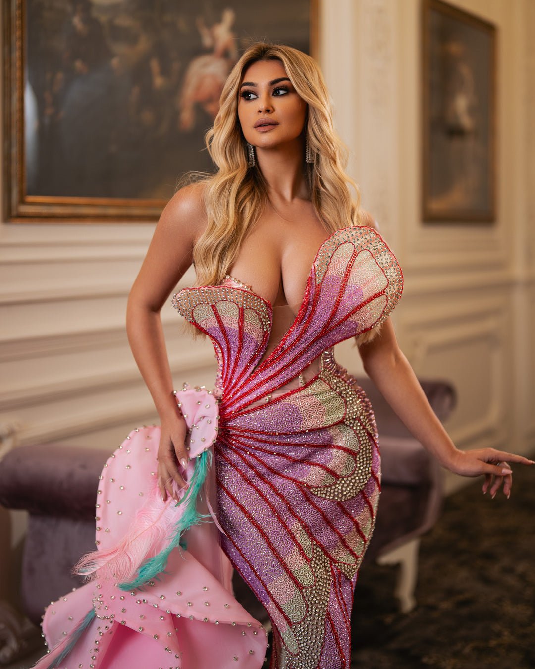 Elegant pink gown with ruffles, crystals, and feathers.