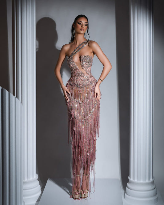 Elegant light pink dress with asymmetrical neckline and delicate tassel and crystal embellishments.