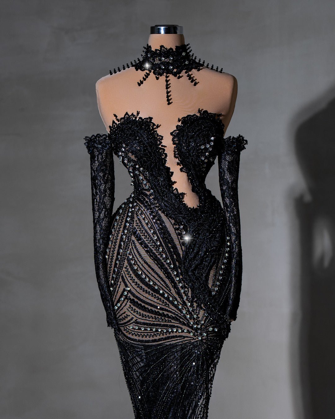 Elegant black lace gown with crystal details and high collar.