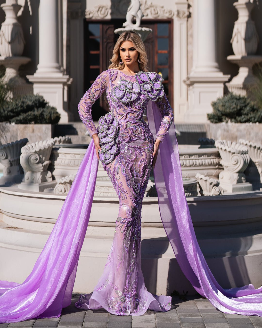 Woman in a flowing purple dress with intricate flower design.