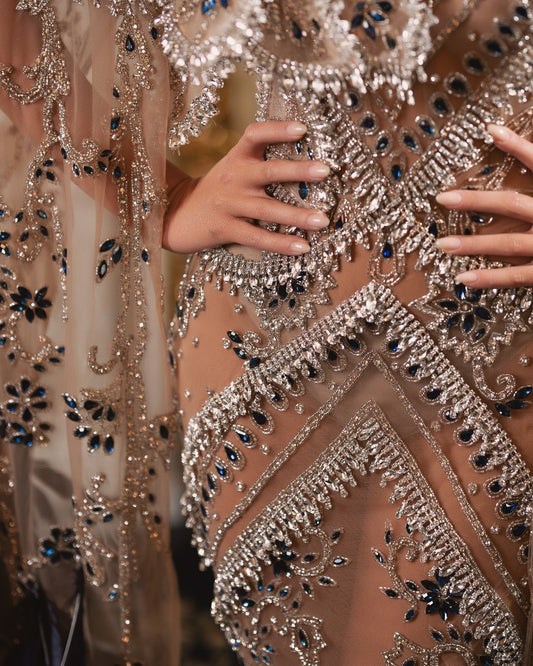 Close-up of silver and navy blue stone embellishments on dress