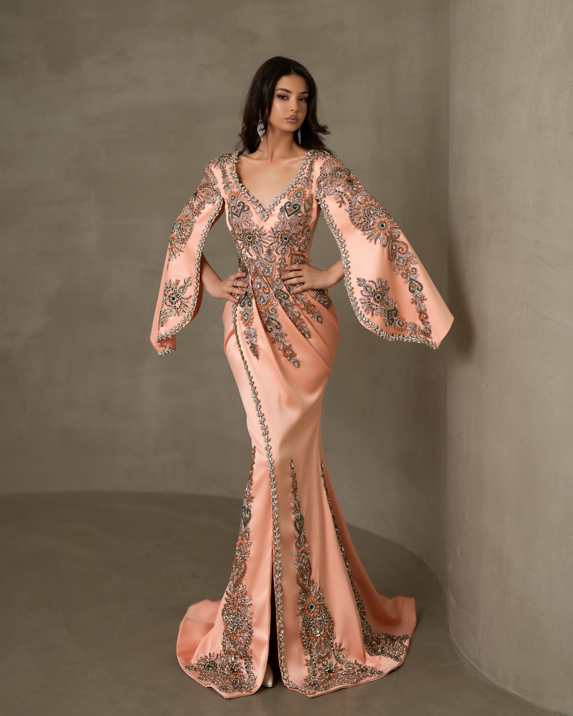  Long dress with lace, stones, and captivating cape sleeves.