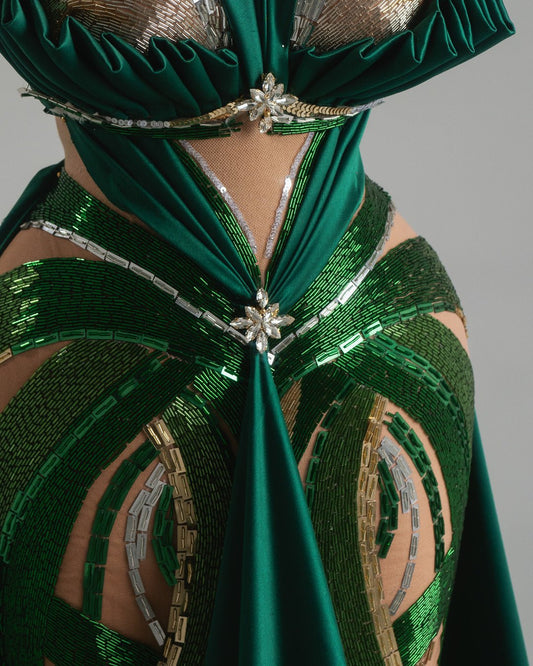 Dramatic emerald dress with intricate crystal accents and flowing skirt.