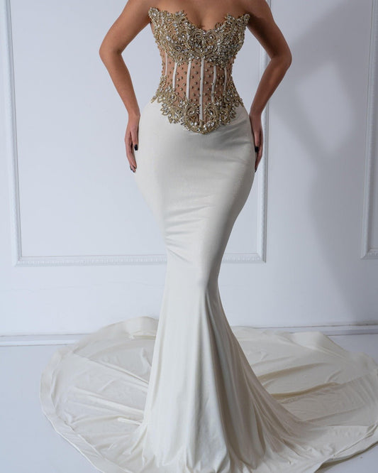 A luxurious floor-length dress with crystal embellishments, featuring a sleeveless design and elegant silhouette.