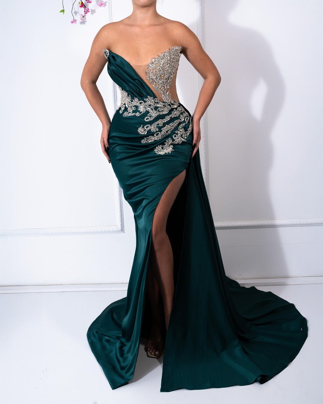 
Emerald green satin dress with crystals, sleeveless design, and a deep slit.






