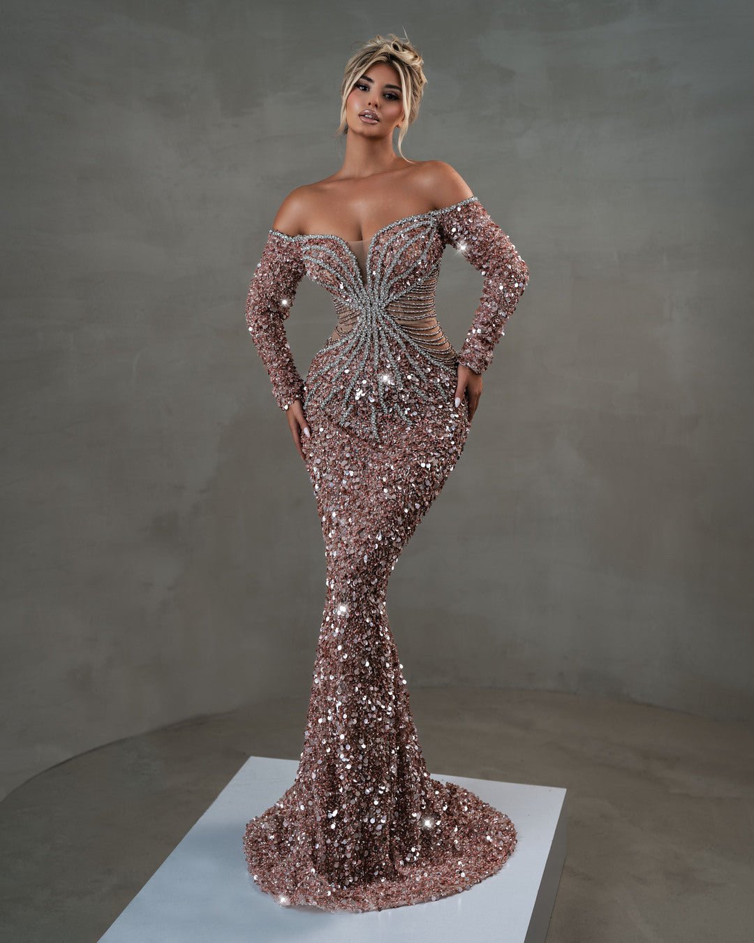 Off-shoulder light pink gown with long sleeves and shimmering silver accents