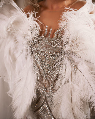 Close-up of intricate silver crystal embellishments on white lace dress