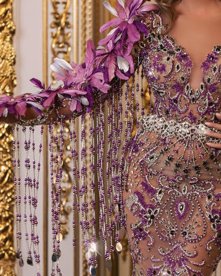 Close-up of detailed feather and bead embellishments on purple dress