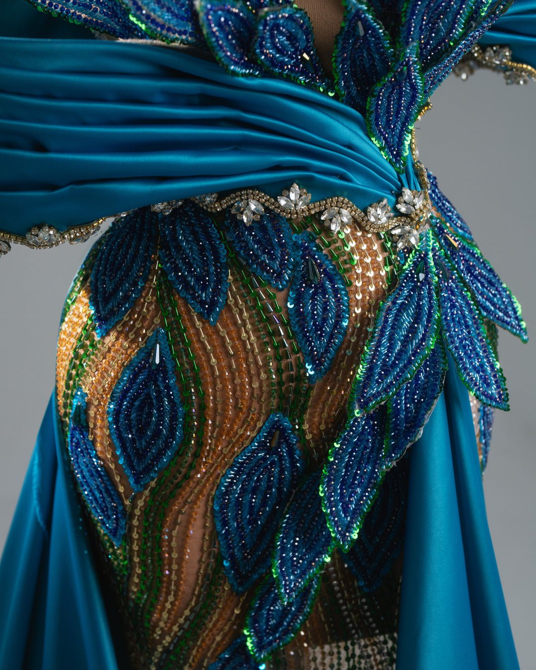 Off-shoulder blue couture dress with sparkling leaf embroidery and dramatic train.