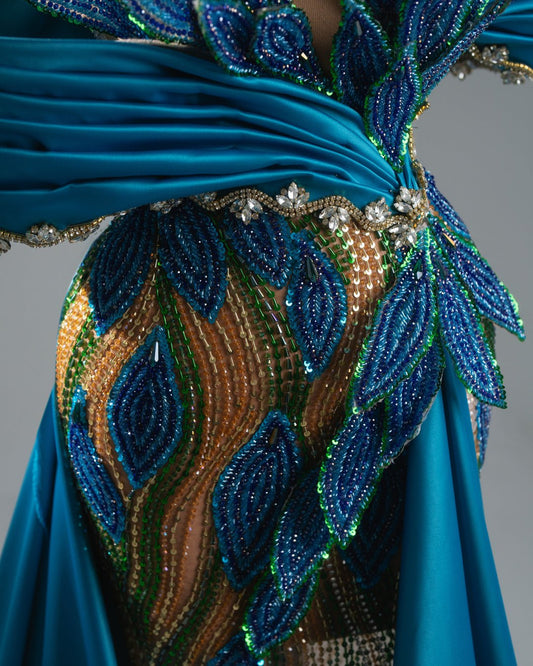 Off-shoulder blue couture dress with sparkling leaf embroidery and dramatic train.