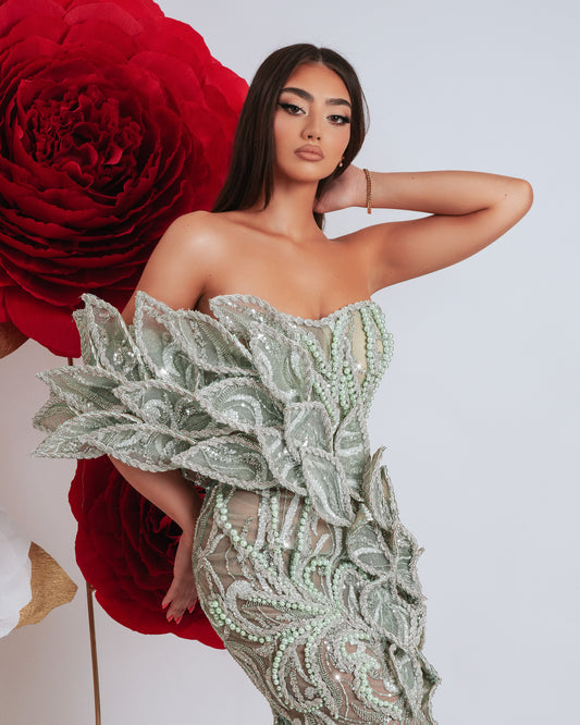 Elegant long sleeveless dress in light green with 3D leaf embellishments and deep leg slit.