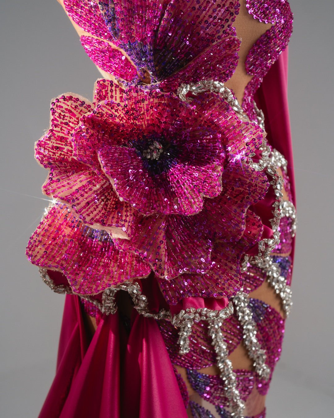 Soft pink one-shoulder dress with a bold flower design and sparkling crystal details.