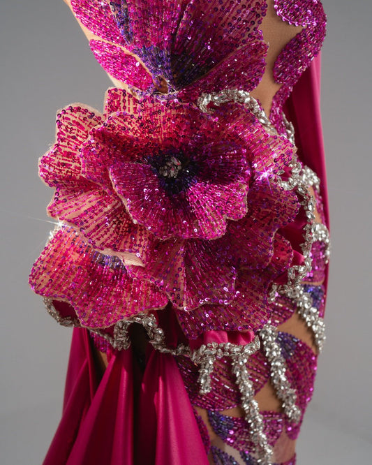 Soft pink one-shoulder dress with a bold flower design and sparkling crystal details.