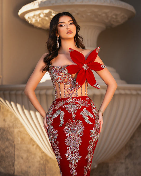 Elegant red velvet gown with floral and crystal accents.