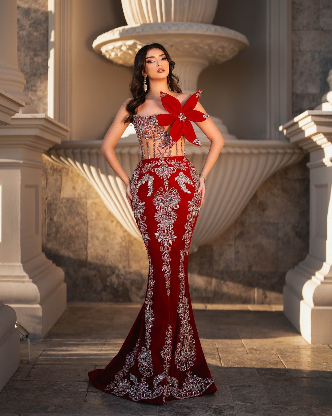 Red dress featuring an oversized flower and intricate crystals.