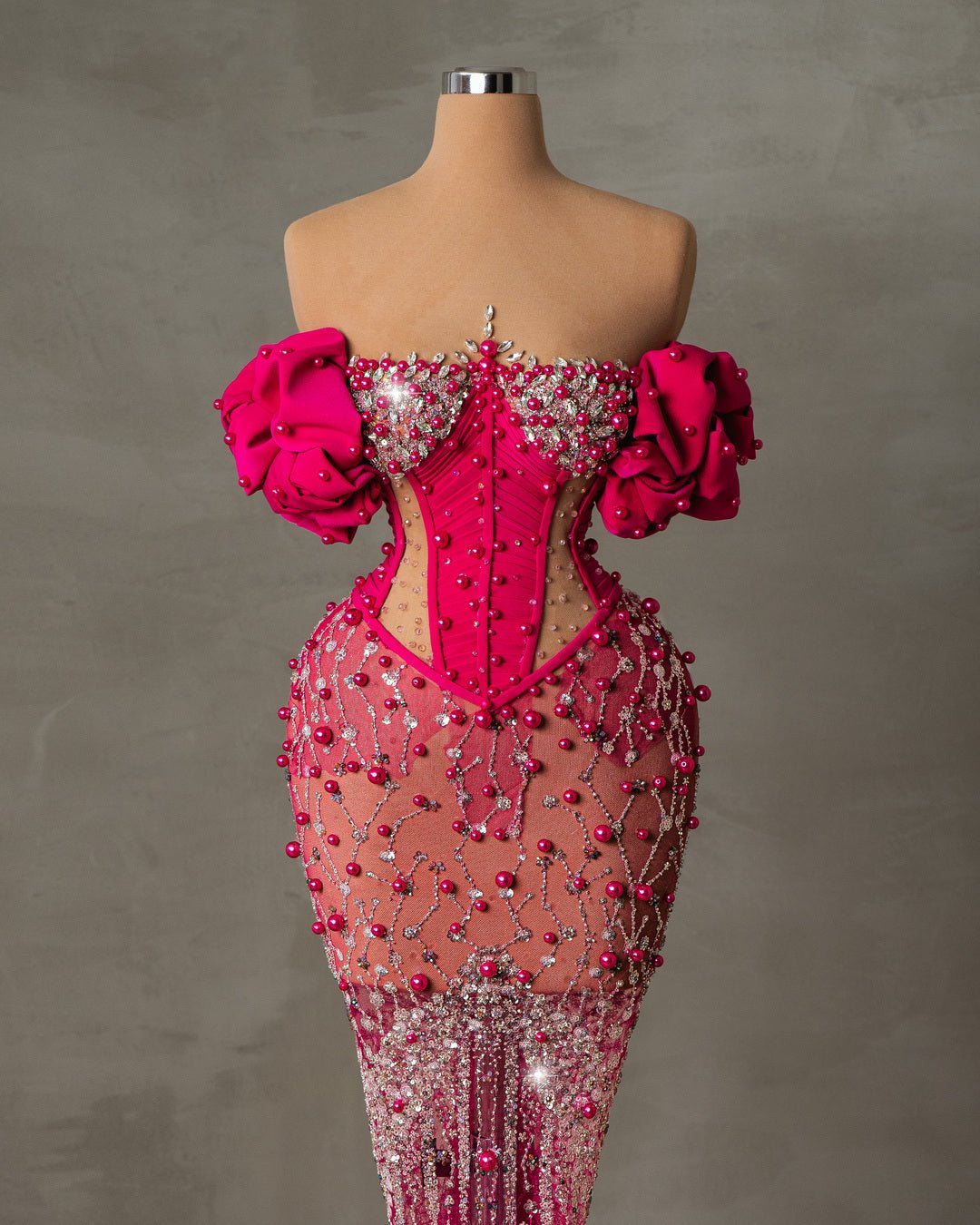 "Elegant Mae Pink Dress with a fitted bodice and pearl embellishments at the neckline and waist.