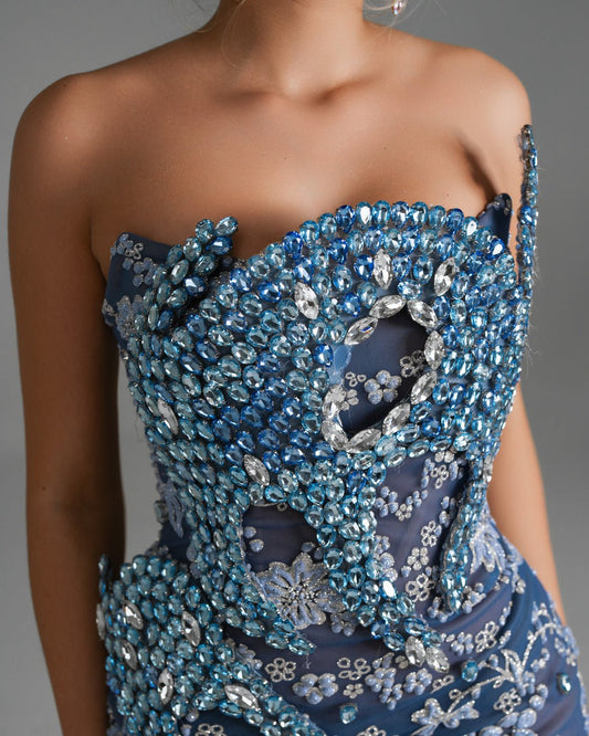 Figure-hugging sheer blue gown with a dramatic flared hemline.