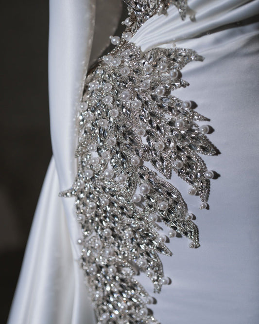 Sophisticated bridal dress with a flattering silhouette and intricate crystal and pearl details.