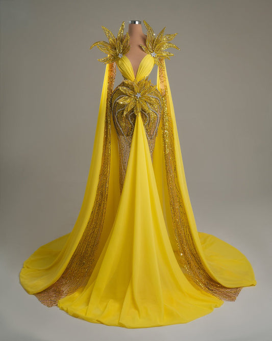 Yellow dress with crystal accents, floral details, and shoulder cape.