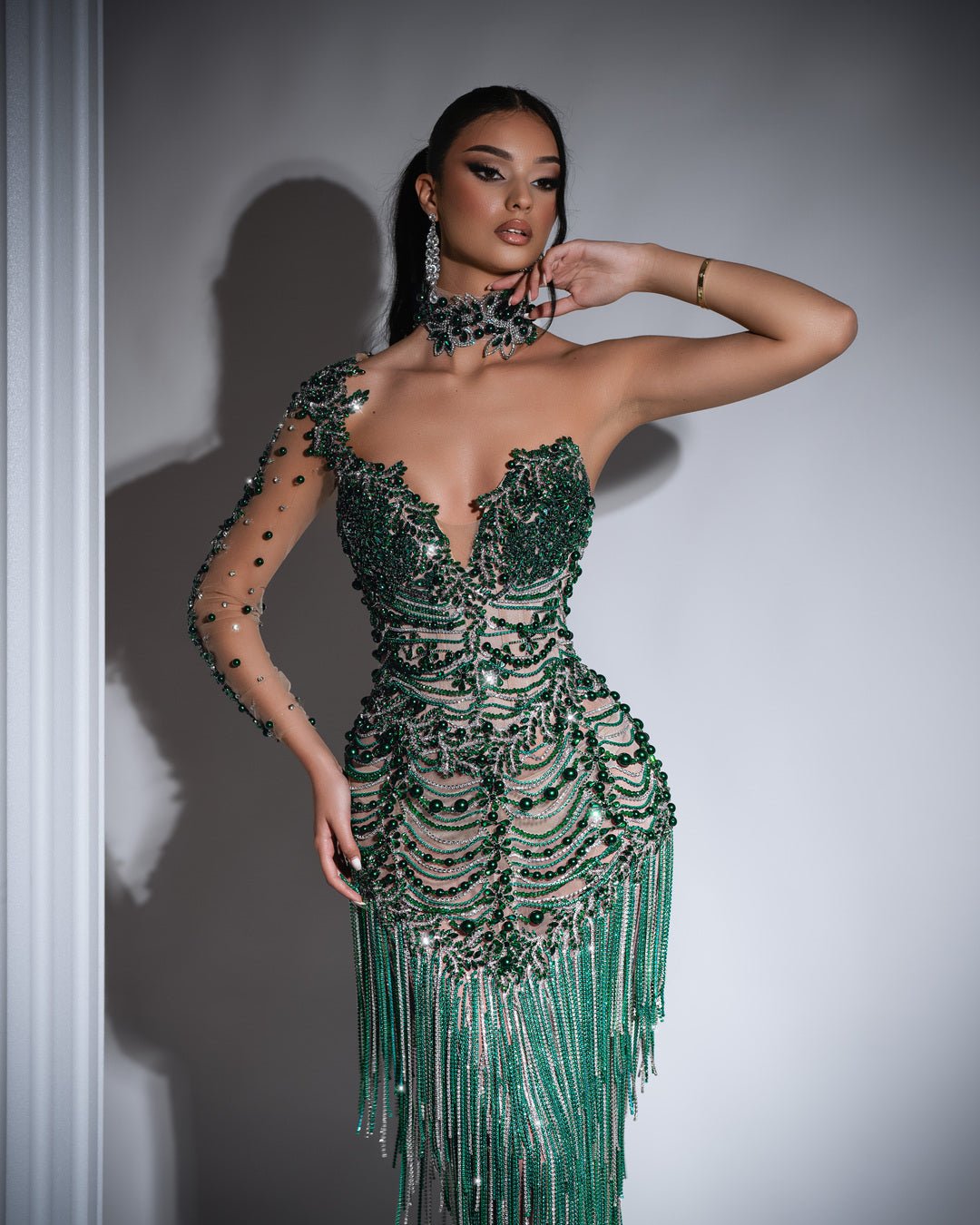 Stylish green dress featuring silver tassels and green bead embellishments.