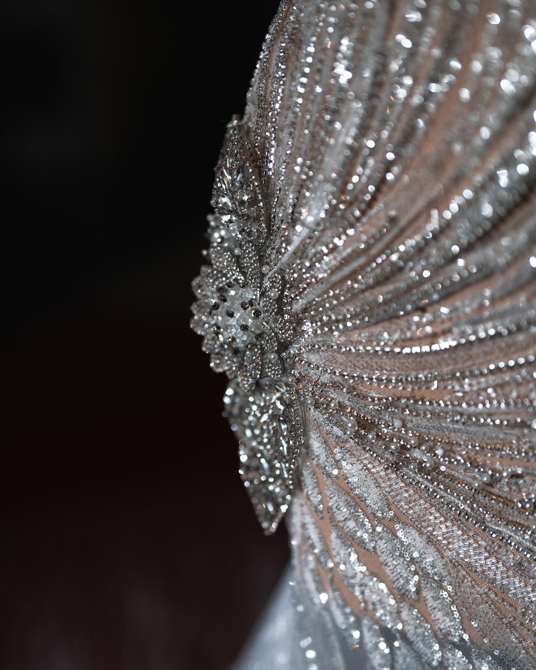 Elegant one-shoulder bridal gown with intricate crystal embellishments, showcasing a swirl pattern and a luxurious, fitted design.