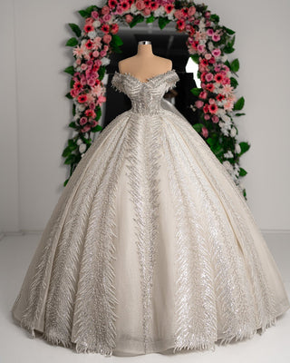 A stunning off-shoulder bridal dress, crafted from luxurious lace and adorned with sequins.