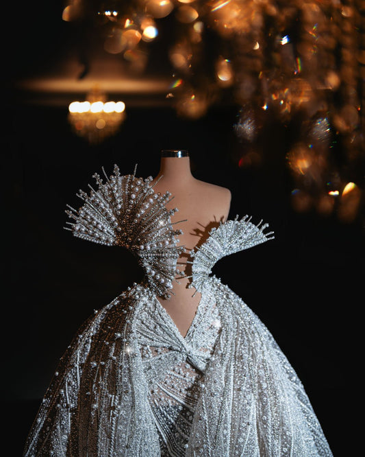 Elegant bridal gown with sparkling bead embellishments and a detachable overskirt, exuding timeless sophistication.