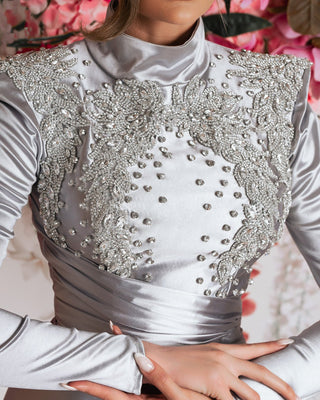 Close-up detail of stunning silver short dress - showcasing intricate stone embellishments.