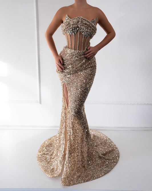 
Handcrafted gold dress with crystals, beads, and a deep slit for elegant allure.