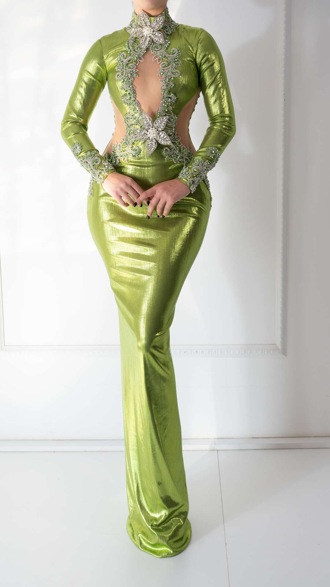 A light green dress with floral embroidery, crystals, and an open chest design.