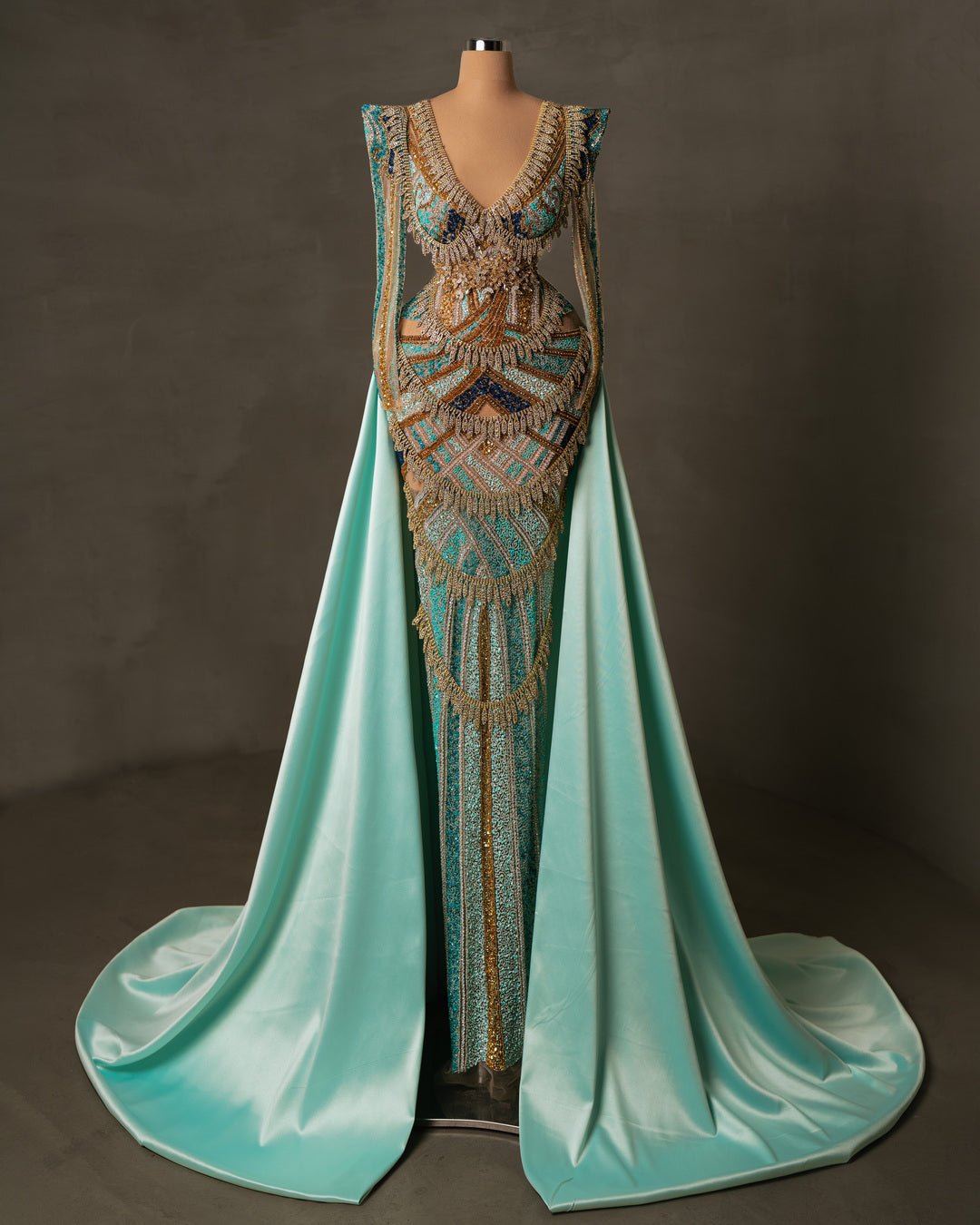 Luxury aqua dress with long sleeves, V-neck, and satin overskirt embellished with beads and stones