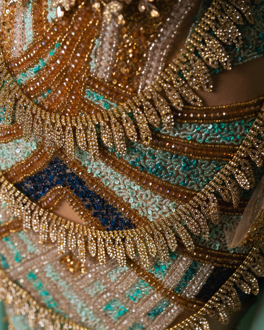 Close-up of bead and stone embellishments on aqua dress fabric