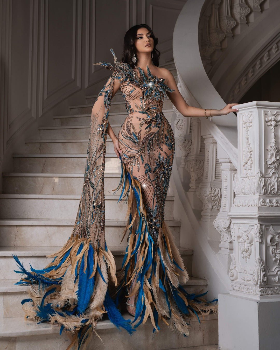 Elegant one-shoulder dress featuring feathers on the shoulder.