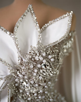 Close-up view capturing the intricate embellishments of crystals and pearls on the sleeveless bridal gown.
