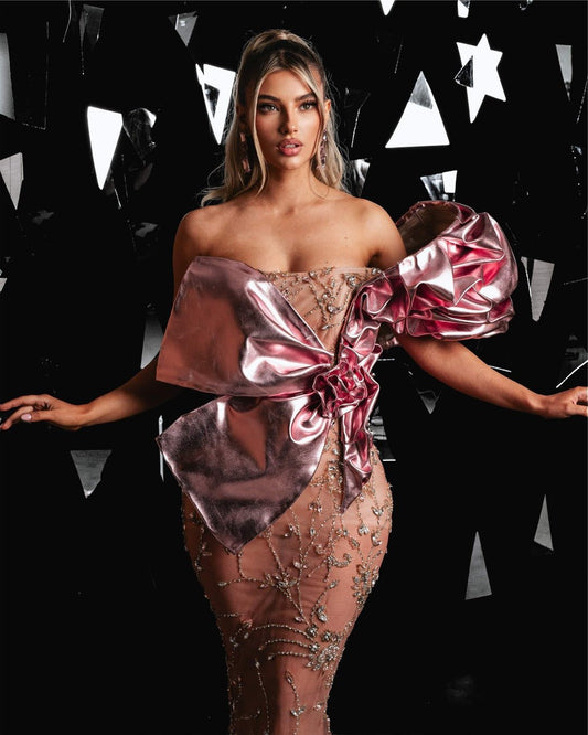 Luxurious long gown in soft pink hue featuring intricate embellishments and 3D metallic leather design