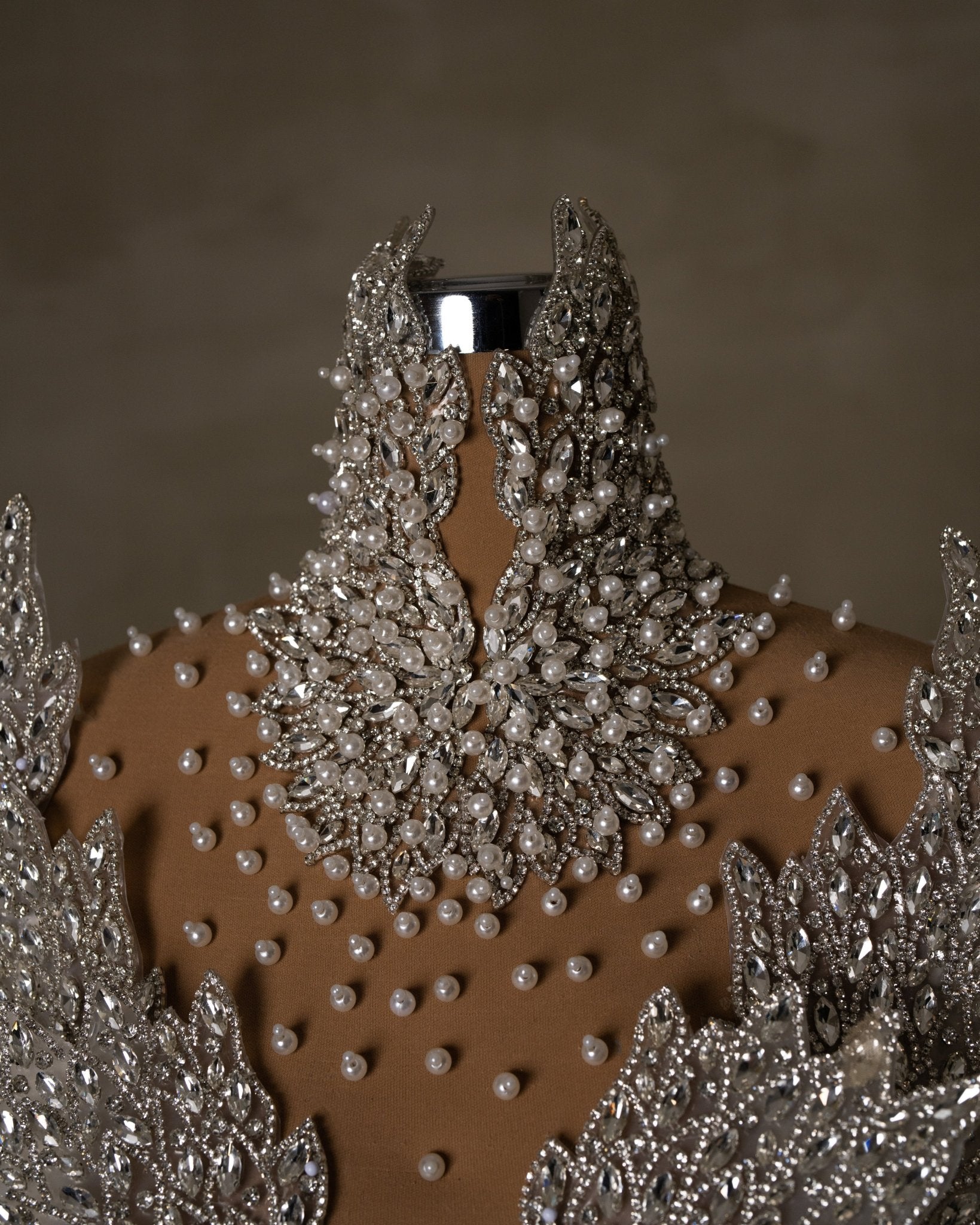 High neck adorned with crystals and pearls.