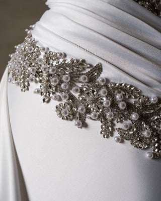 Delicate pearls and crystals accentuate the dress.