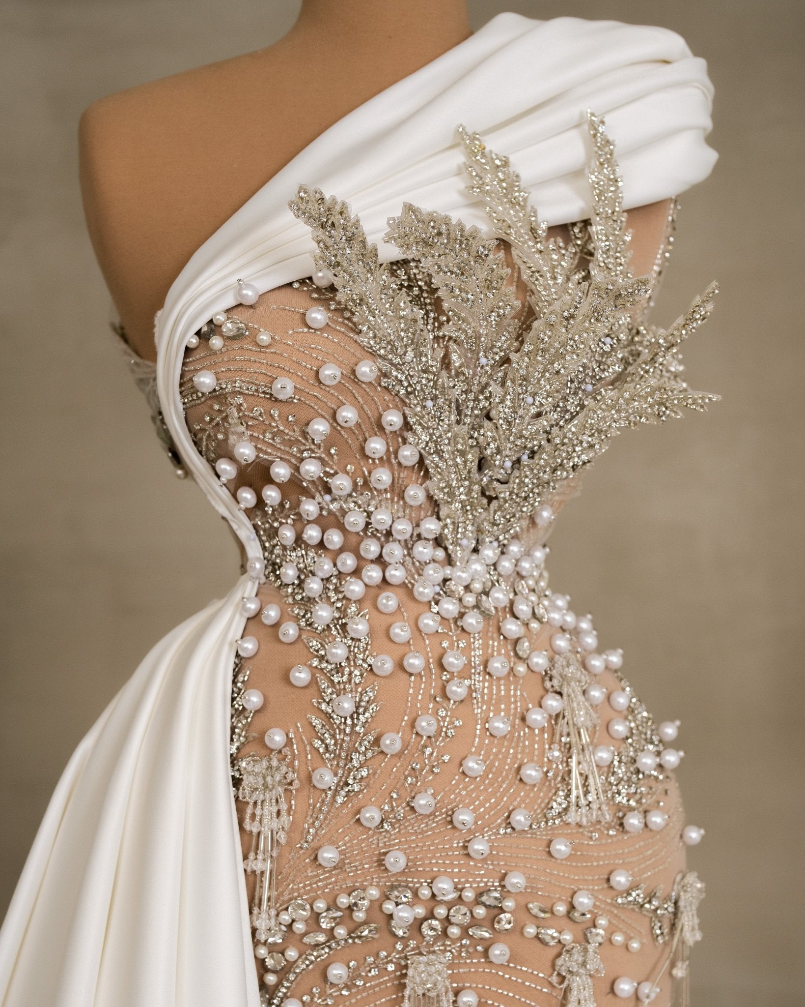 Charming asymmetry: Ruffle neckline and crystal leaf motif