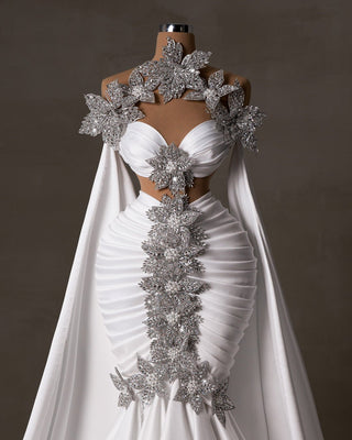 Stunning bridal dress with crystals, pearls, side cape, and cut-outs.