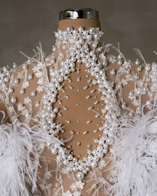 Intricate Feather and Pearl Details on Bridal Dress Close-Up