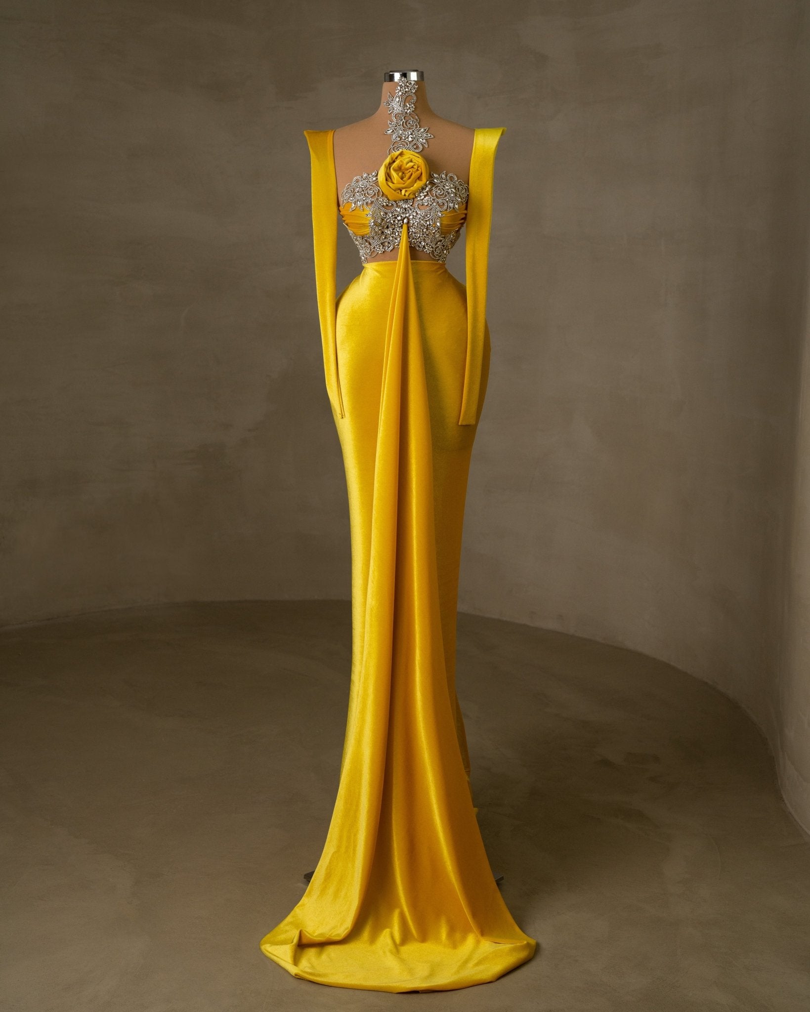 Elegant yellow velvet dress with silver detailing and floral accent.