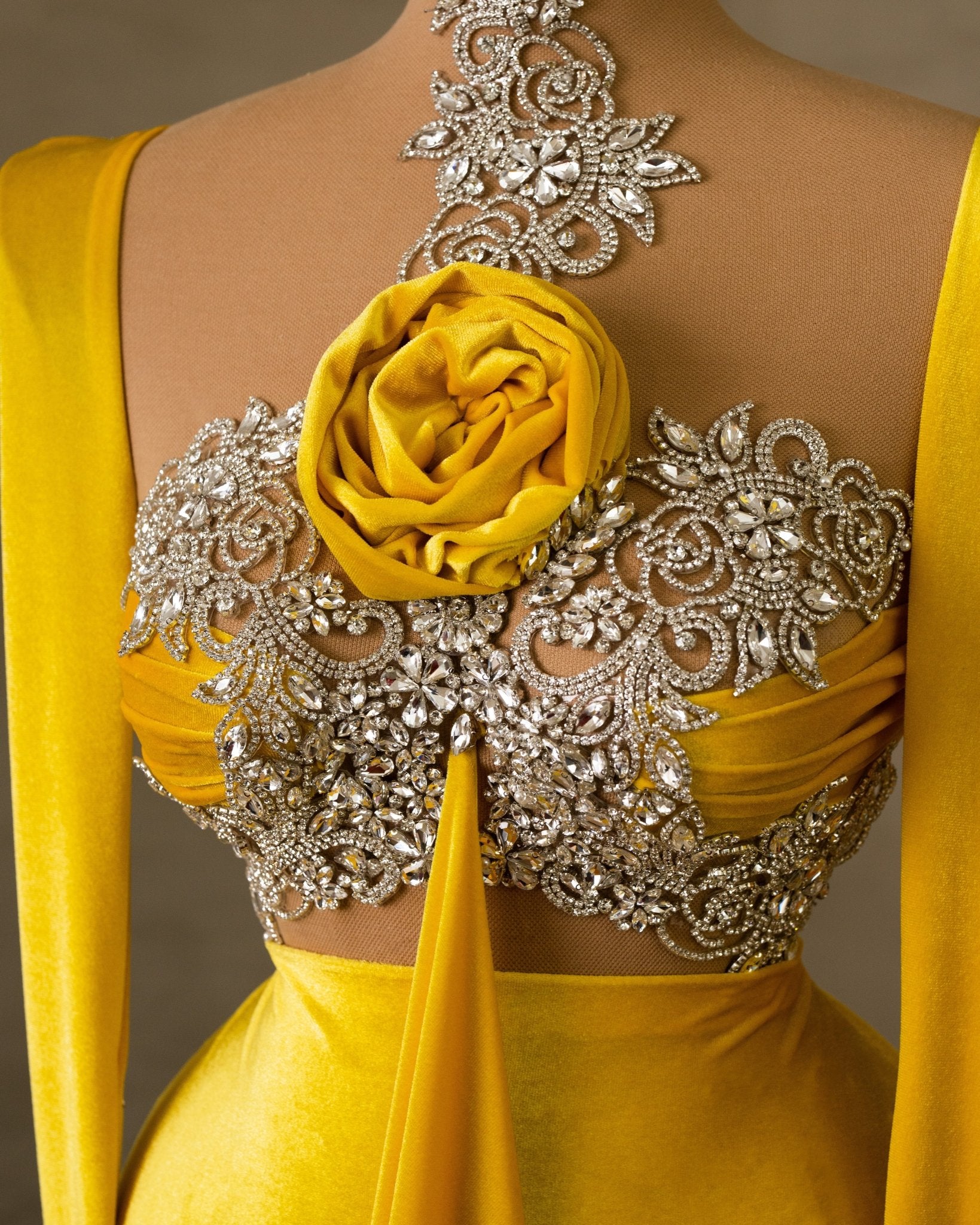 Close-up of silver embellishments on a yellow velvet dress.