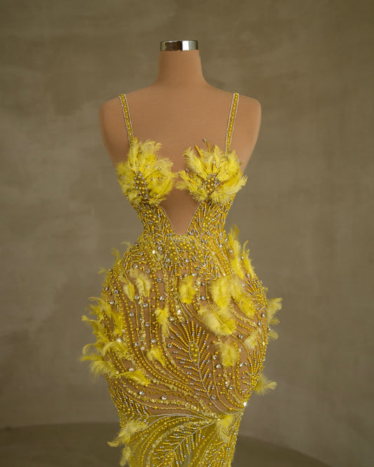 Sleeveless dress featuring exquisite stone and feather embellishments with thin straps